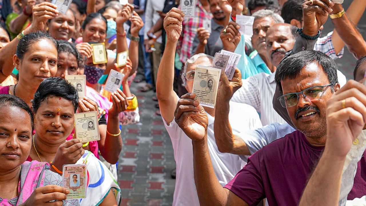 People wait in queues at a polling station to cast their votes for Karnataka Assembly elections, in Bengaluru, Wednesday, May 10, 2023. Credit: PTI Photo