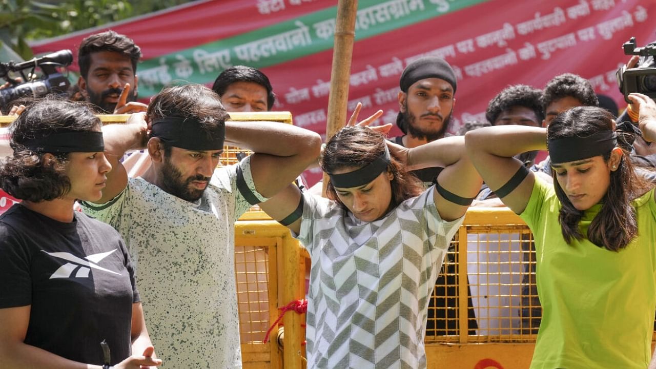 Wrestlers wear black bands during their ongoing protest against Wrestling Federation of India (WFI) chief Brij Bhushan Sharan Singh, at Jantar Mantar in New Delhi, Thursday, May 11, 2023. Credit: PTI Photo