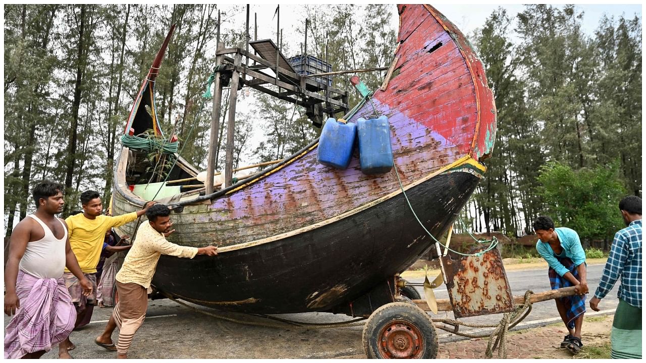 Fishermen shift a boat to a safer place in Teknaf on May 13, 2023, ahead of Cyclone Mocha landfall. Credit: AFP Photo