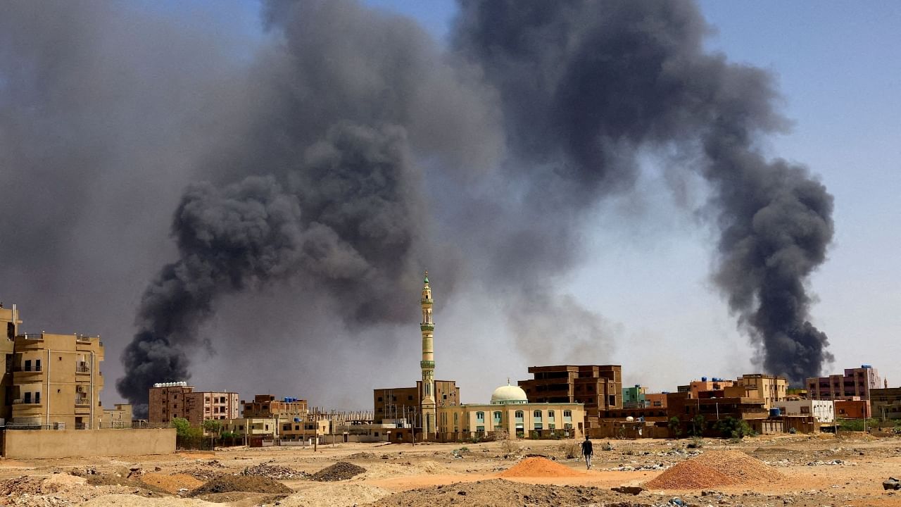A man walks while smoke rises above buildings after aerial bombardment, during clashes between the paramilitary Rapid Support Forces and the army in Khartoum North, Sudan, May 1, 2023. Credit: Reuters File Photo