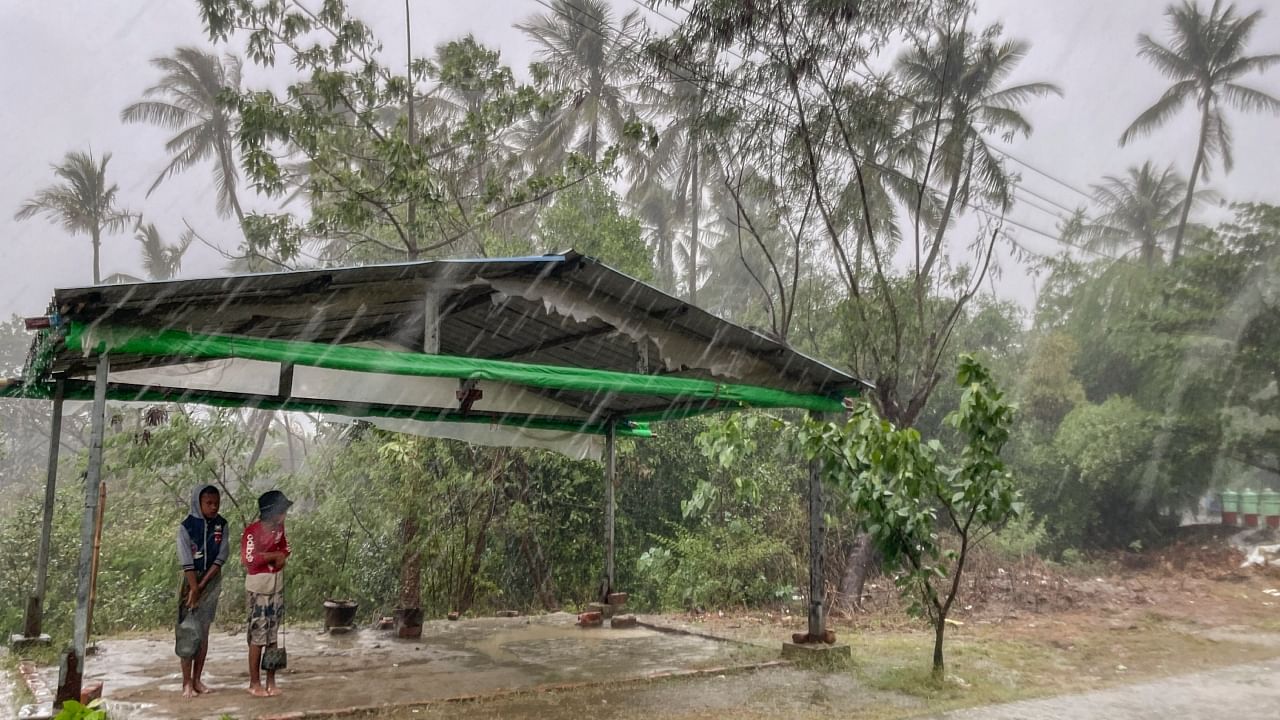 Two children stand under a roadside shelter to protect from rain before Cyclone Mocha hits in Sittwe, Rakhine State. Credit: AP Photo