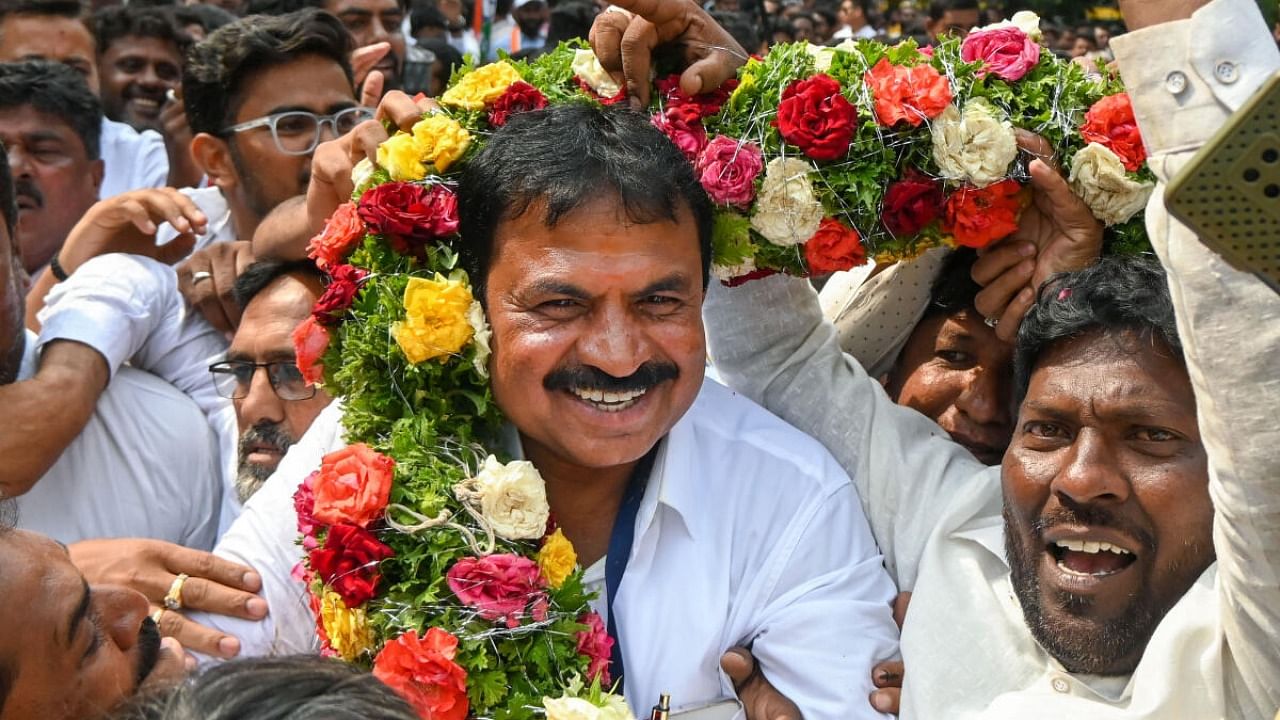 Congress candidate A C Srinivas garlanded amid victory celebrations in Bengaluru. Credit: PTI Photo