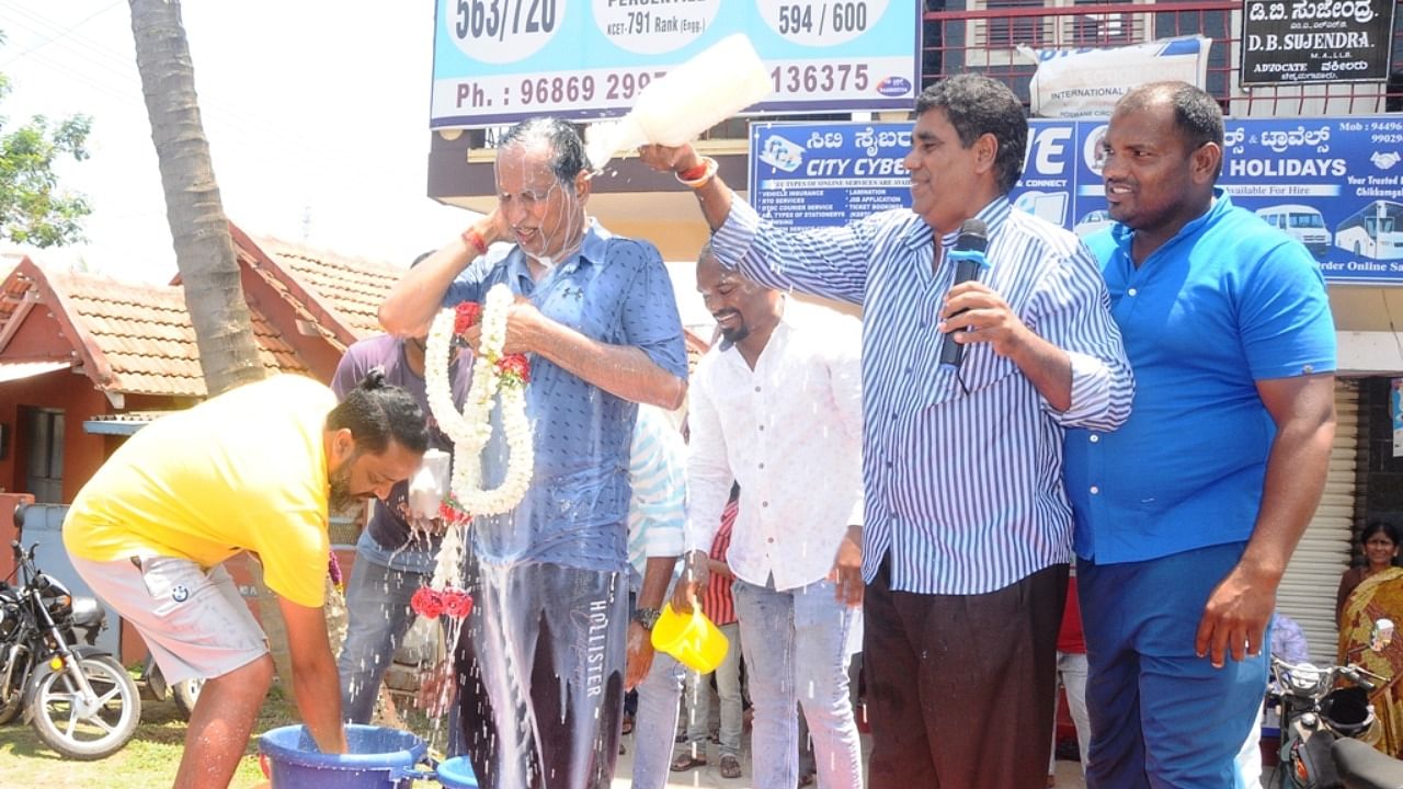 JD(S) workers and leaders pour milk on JD(S) state general secretary S L Bhojegowda at Hosamane Layout circle to celebrate the defeat of BJP in Chikkamagaluru constituency. Credit: DH Photo