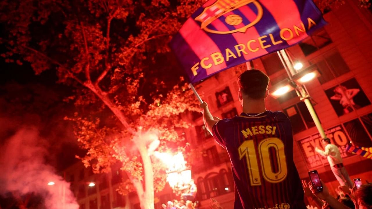 A Barca fan celebrates the club's La Liga win with a Messi shirt on. Credit: Reuters Photo