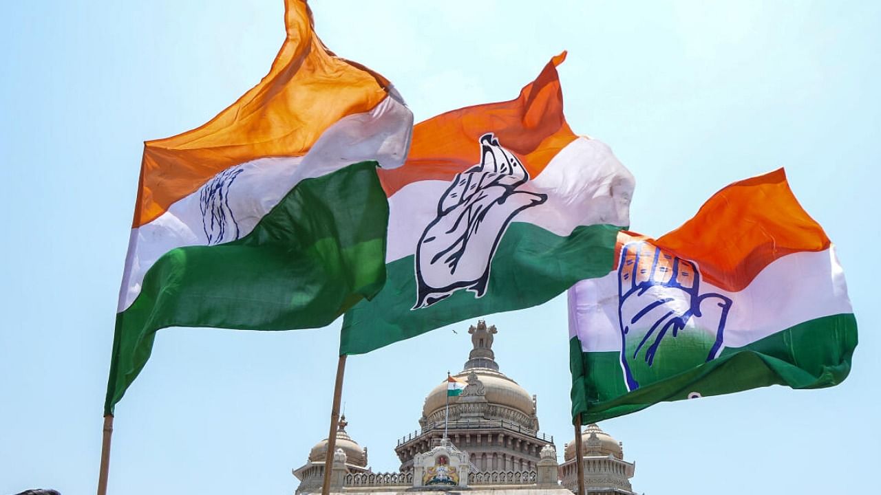 Congress workers holding the party flag celebrate the party's win in Karnataka Assembly elections, outside Vidhana Soudha in Bengaluru. credit: PTI Photo