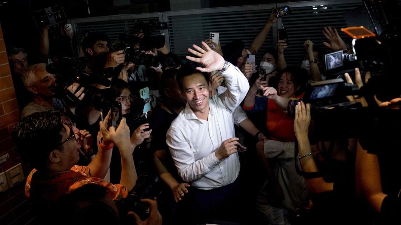 Move Forward Party leader and prime ministerial candidate Pita Limjaroenrat (C) leaves the party’s headquarters as votes continue to be counted. credit: AFP Photo