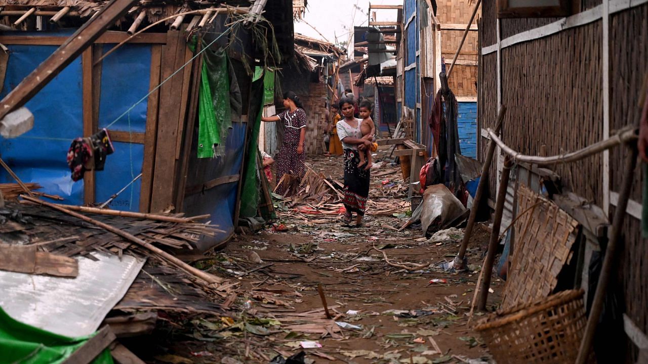 A woman walks through an alley after cyclone Mocha made landfall. Credit: AFP Photo