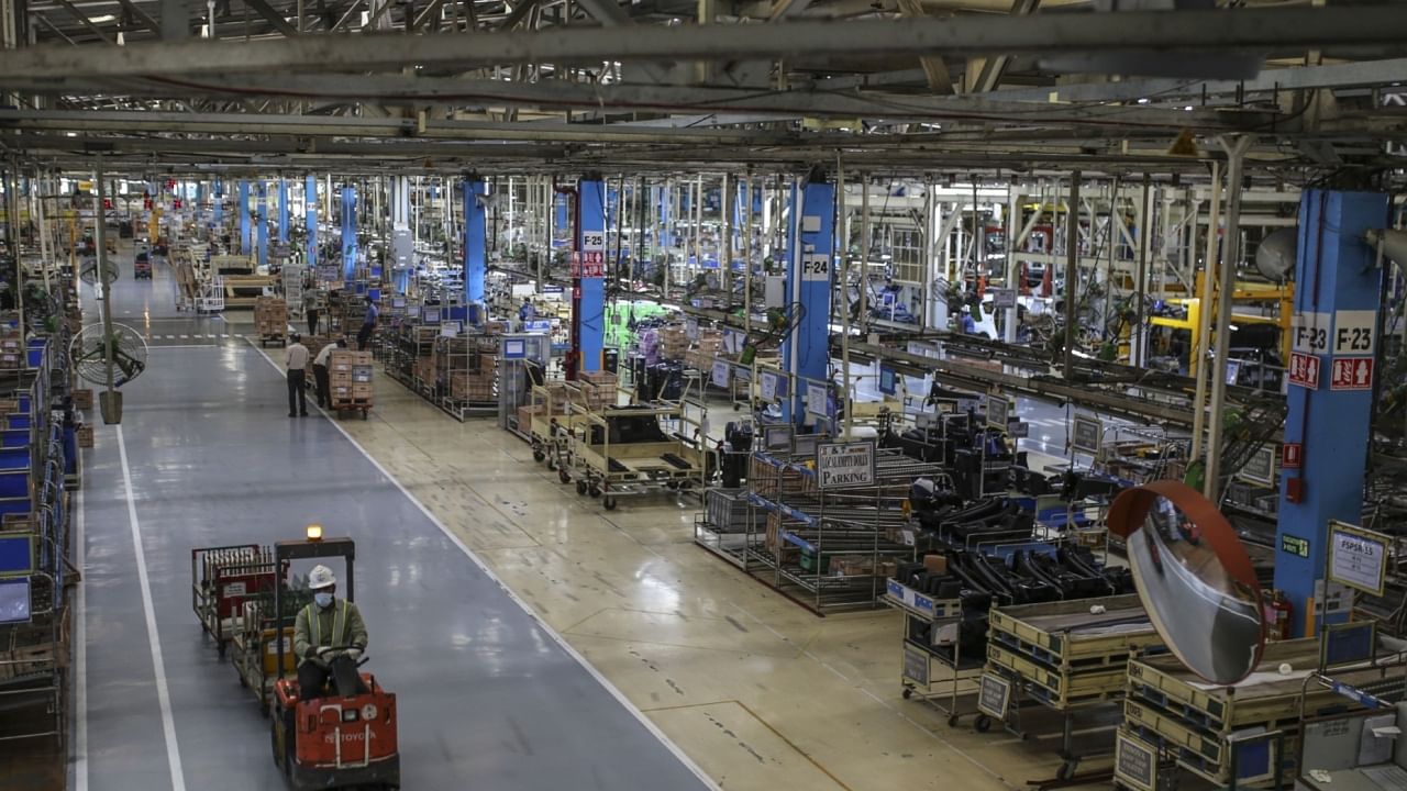 A workers drives a tug through the Innova Crysta compact multi-purpose vehicle (MPV) production line at the Toyota Kirloskar Motor Ltd. plant in Bidadi, Karnataka. Credit: Bloomberg file photo