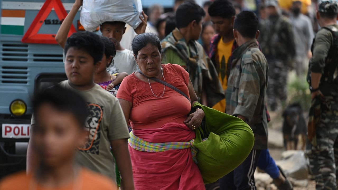 Meitei refugees queue along to board a paramilitary truck at a transit point after being evacuated from the violence that hit Churachandpur. Credit: AFP Photo