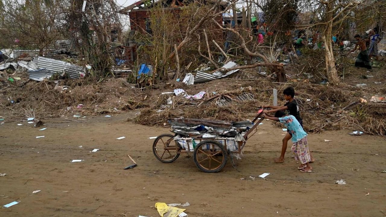 Children push a cart full of debris at the Khaung Dote Khar Rohingya refugee camp in Sittwe, in Myanmar's Rakhine state, on May 15, 2023, after cyclone Mocha made a landfall. Credit: AFP Photo