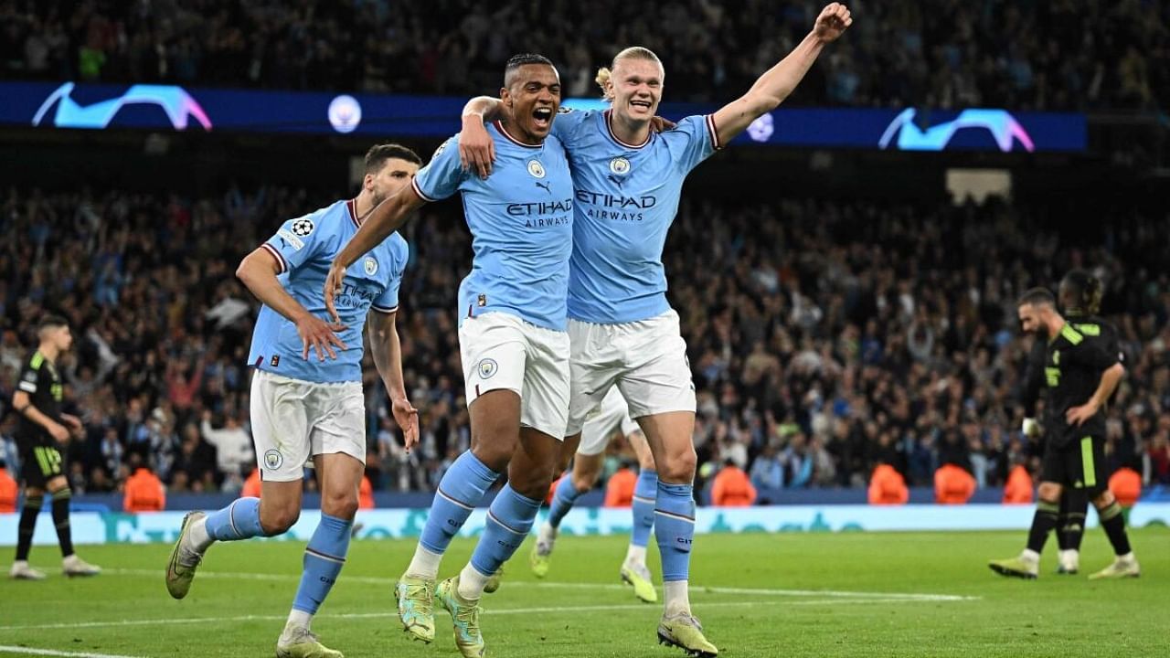 Manchester City's Swiss defender Manuel Akanji (L) celebrates scoring the team's third goal with Manchester City's Norwegian striker Erling Haaland during the UEFA Champions League second leg semi-final football match between Manchester City and Real Madrid at the Etihad Stadium in Manchester, north west England, on May 17, 2023. Credit: AFP Photo
