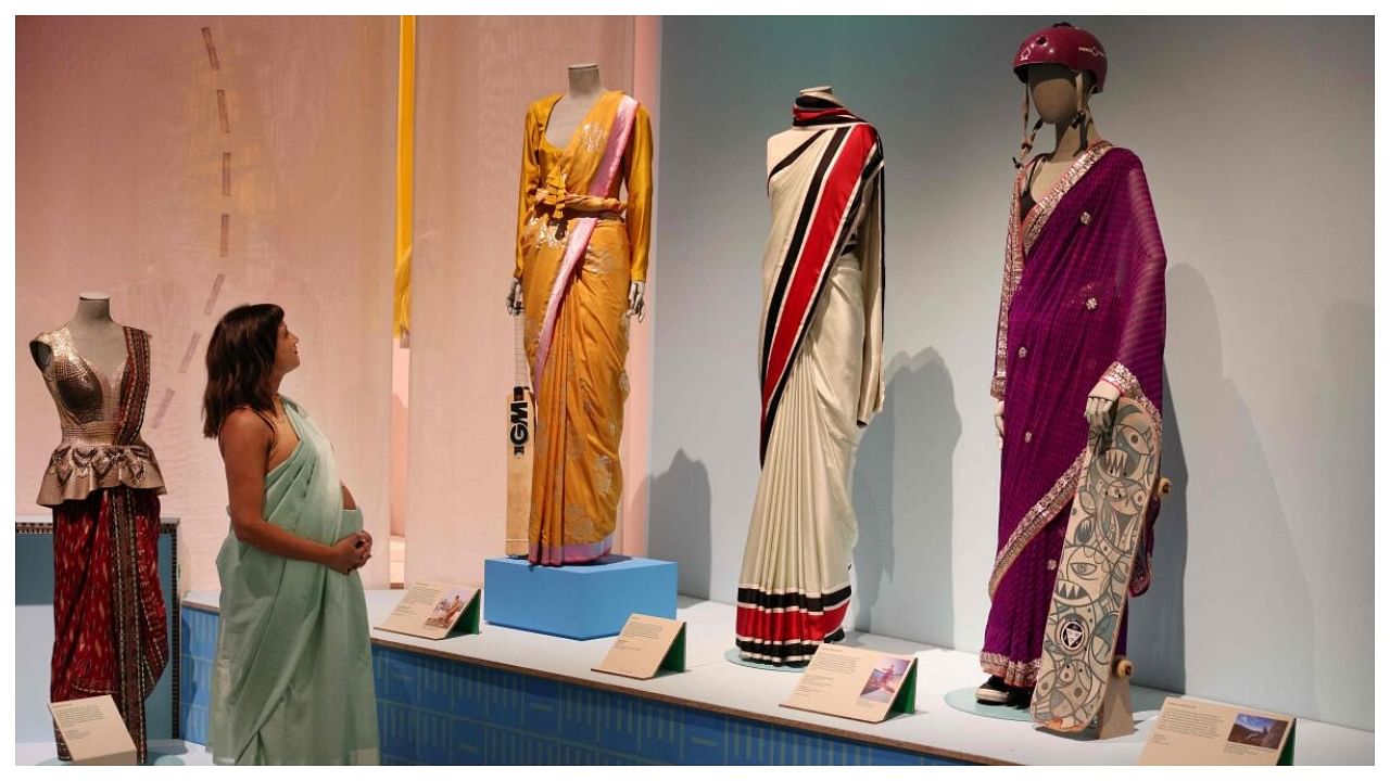 Design Museum's Head of Curatorial Priya Khanchandani looks at some of the saris displayed at the Design Museum, in London, on May 17, 2023, during the press preview of the exhibition 'The Offbeat Sari'. Credit: AFP Photo