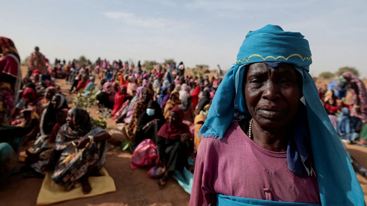 Halime Adam Moussa, a Sudanese refugee who is seeking refuge in Chad for a second time, waits with other refugees to receive a food portion from World Food Programme (WFP), near the border between Sudan and Chad in Koufroun, Chad, May 9, 2023. Credit: Reuters Photo