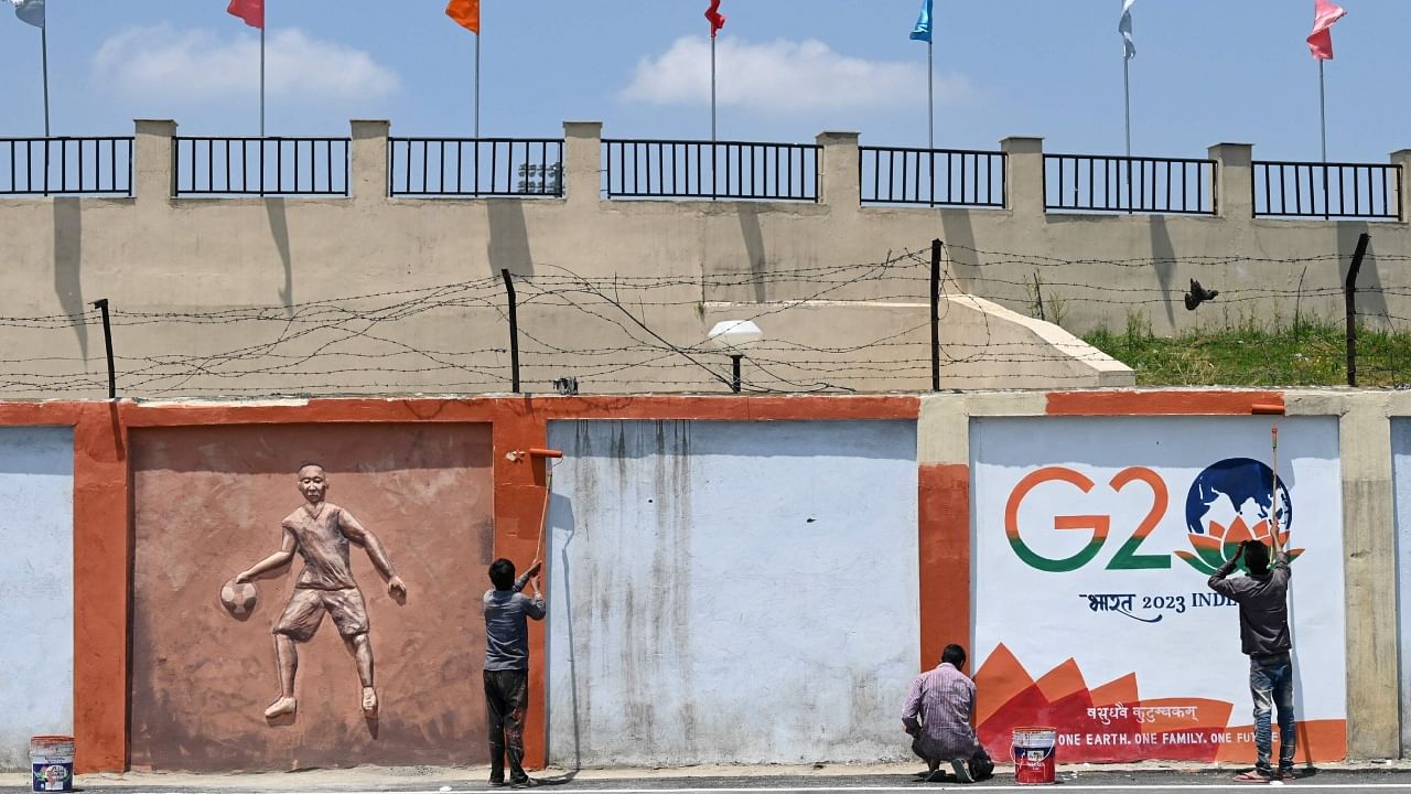 Painters give final touches to a wall mural along a street ahead of the G20 meeting in Srinagar on May 19, 2023. Credit: AFP Photo