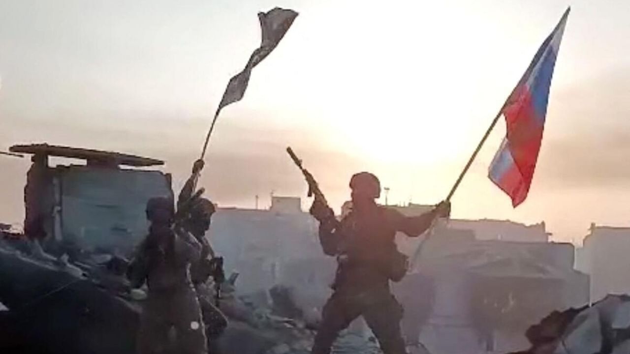 This video grab taken from a handout footage posted on May 20, 2023 on the Telegram account of the press service of Concord -- a company linked to the chief of Russian mercenary group Wagner, Yevgeny Prigozhin -- shows members of Wagner group waving a Russian national flag and Wagner Group's flag on the rooftop of a damaged building in Bakhmut, amid the Russian invasion of Ukraine. Credit: Reuters Photo