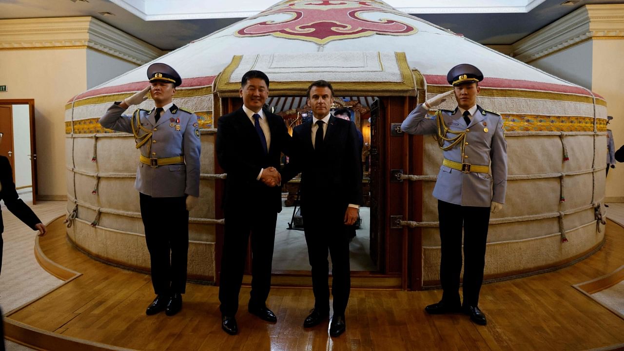 Mongolia's President Ukhnaagiin Khürelsükh receives France's President Emmanuel Macron during a ceremonial welcome at the Government Palace in Ulaanbaatar. Credit: AFP Photo