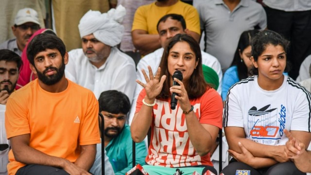 Wrestlers Bajrang Punia, Vinesh Phogat and Sakshi Malik speak with the media during their protest at Jantar Mantar, in New Delhi, Sunday, April 30, 2023. Credit: PTI Photo