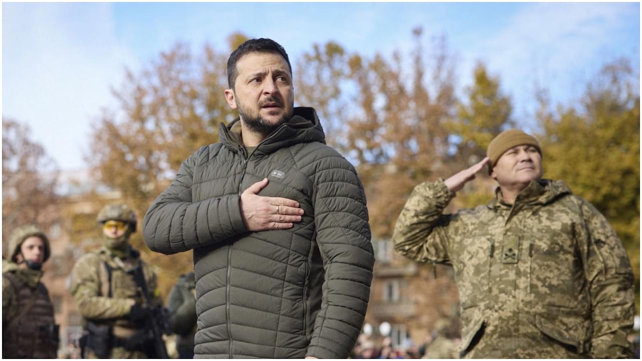 In this photo provided by the Ukrainian Presidential Press Office, Ukrainian President Volodymyr Zelenskyy listens to the national anthem during his visit to Kherson, Ukraine, Monday, Nov. 14, 2022. Credit: AP Photo