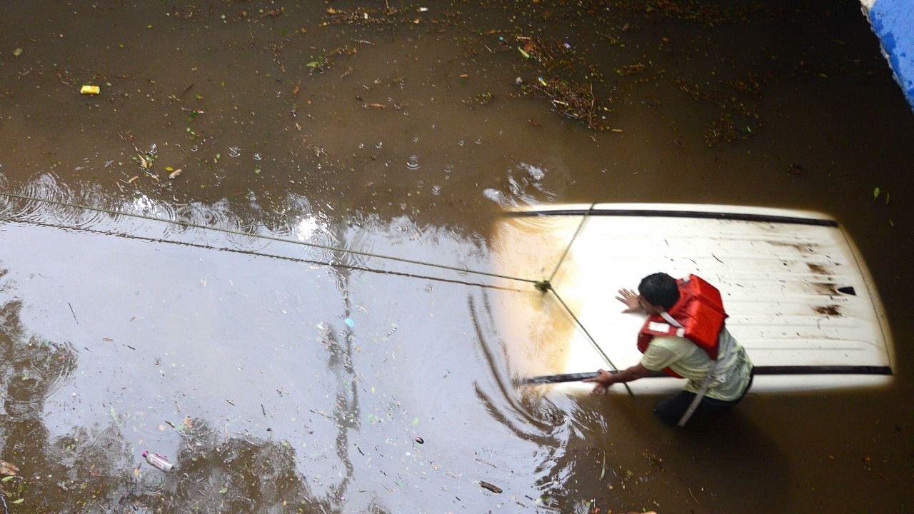  A partially submerged car on a waterlogged street after heavy rainfall in Bengaluru on Sunday. Credit: IANS Photo