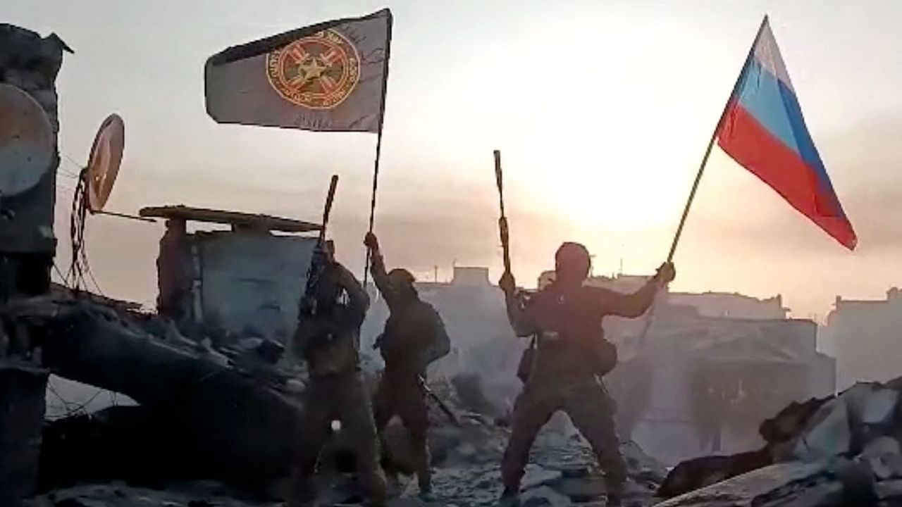 Wagner mercenary group fighters wave flags of Russia and Wagner group on top of a building in an unidentified location, in the course of the Russia-Ukraine conflict, in this still image obtained from a video released on May 20, 2023, along with a statement by Russian mercenary chief Yevgeny Prigozhin about taking full control of the Ukrainian city of Bakhmut. Press service of Concord/Handout via Reuters Photo