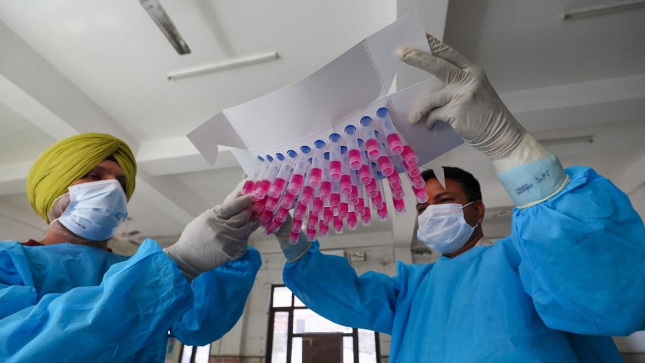 Healthcare workers show swab samples for Covid-19 test. Credit: PTI File Photo