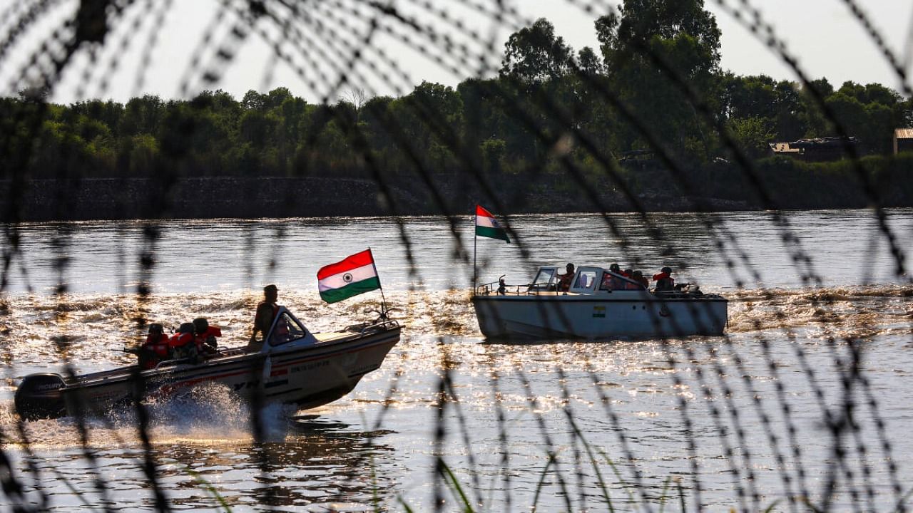 Border Security Force (BSF) soldiers patrol on a boat in the Chenab river amid a high alert in view of the upcoming G20 meeting in J&K's Srinagar. Credit: PTI Photo