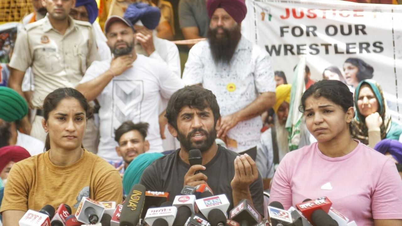 Wrestlers Bajrang Punia, Vinesh Phogat and Sakshi Malik address a press conference at Jantar Mantar in New Delhi on Monday. Credit: PTI Photo
