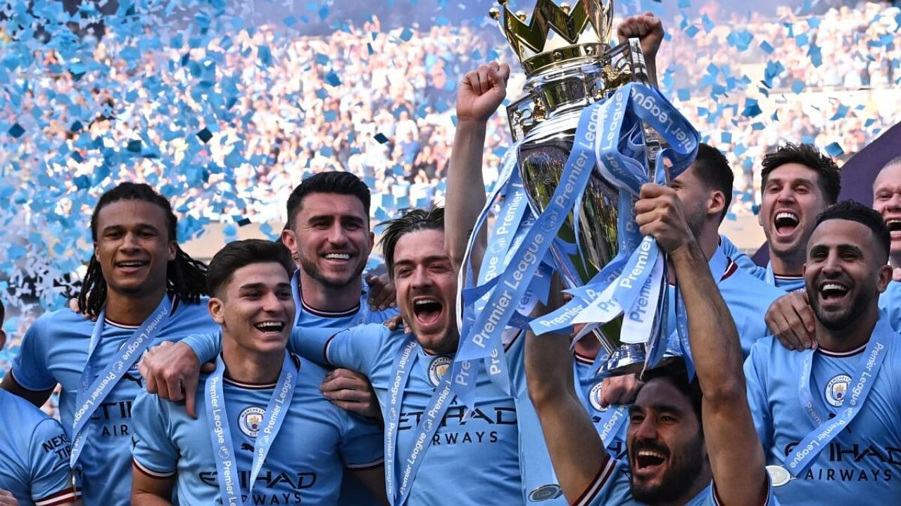 Manchester City's German midfielder Ilkay Gundogan lifts the trophy as Manchester City players celebrate winning the title at the presentation ceremony following the English Premier League football match between Manchester City and Chelsea at the Etihad Stadium. Credit: AFP Photo