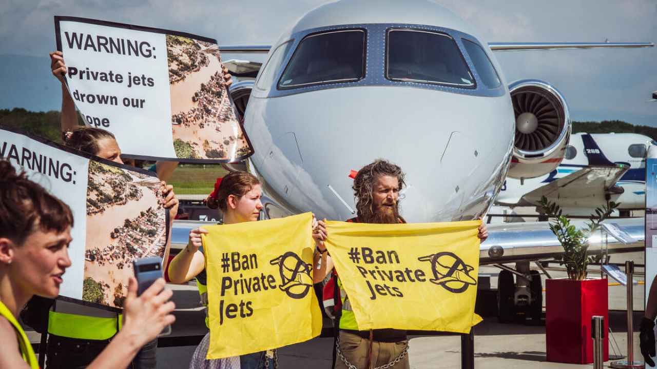 Activists supporting Greenpeace, Stay Grounded, Extinction Rebellion, Scientist Rebellion and other climate movement groups hold banners during a demonstration against Private jets at the European Business Aviation Convention & Exhibition (EBACE) in Geneva, Switzerland, May 23, 2023. Credit: Reuters Photo
