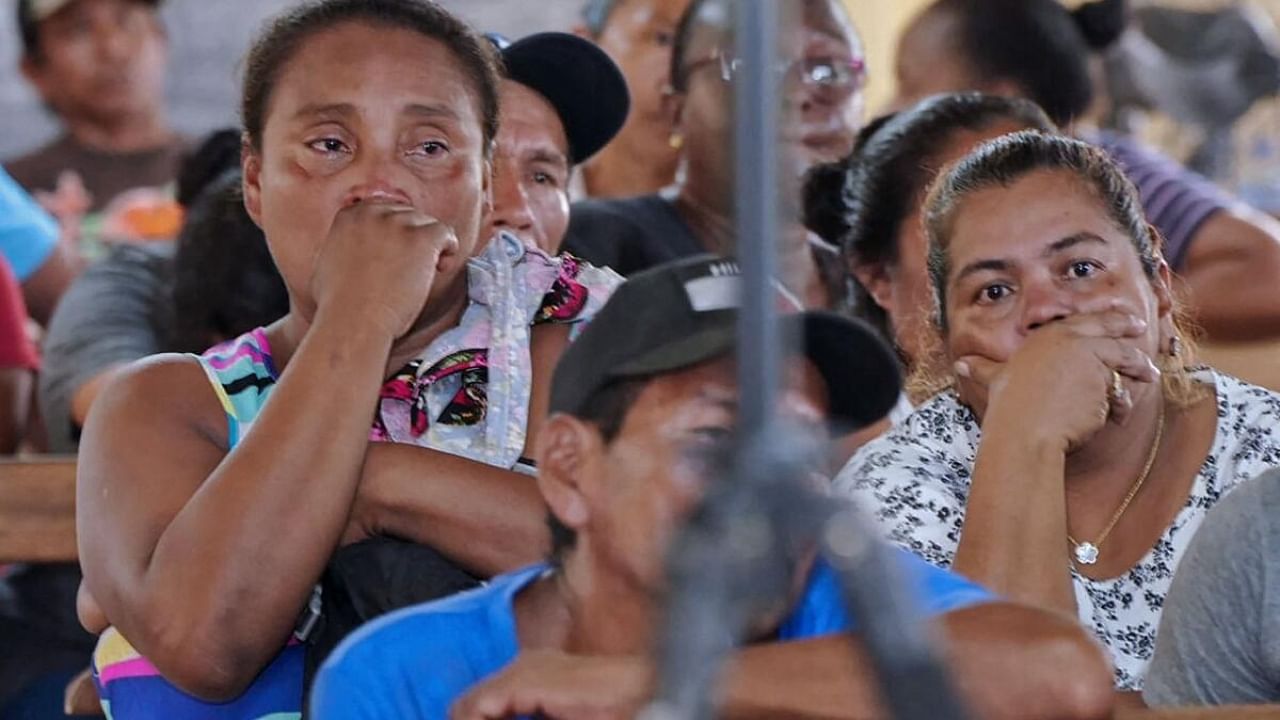 Relatives and friends of the victims of a fire on the eve that killed at least 19 youths and injured about 20 others in a schoolgirls' dormitory, cry during a meeting with Guyana's President Irfaan Ali, in Mahdia, Guyana. Credit: AFP Photo