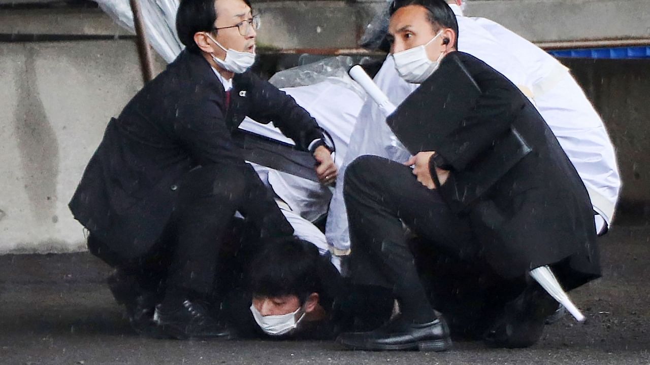 The suspect (bottom) has reportedly remained tight-lipped about his motive for the failed attack on Kishida. Credit: AFP Photo