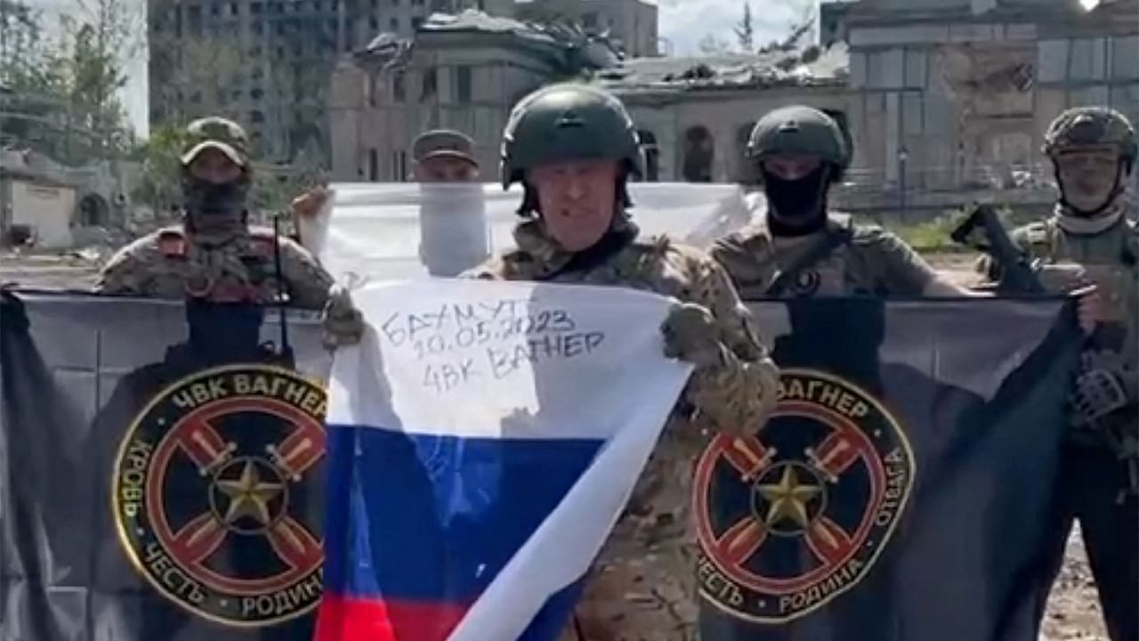 Yevgeny Prigozhin holding a Russian national flag in front of his soldiers holding Wagner Group's flags in Bakhmut, amid the Russian invasion of Ukraine. Credit: AFP Photo/Telegram channel of Concord group