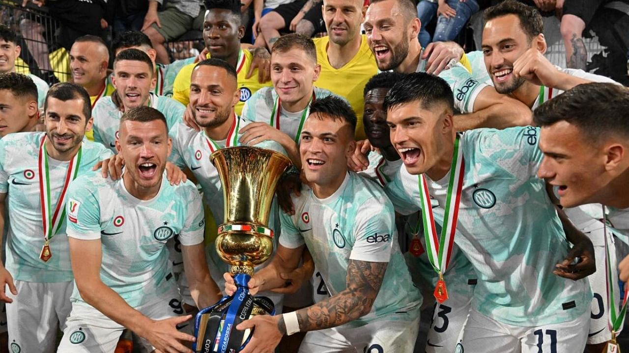 Inter Milan's Argentinian forward Lautaro Martinez (C) and his teammates celebrate with the trophy after winning the Italian Cup (Coppa Italia) final football match between Fiorentina and Inter Milan at the Stadio Olimpico in Rome. Credit: AFP Photo