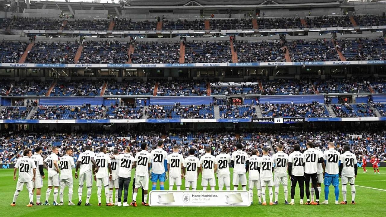 Real Madrid's players wear the jersey of Vinicius Junior in support to the Real Madrid's Brazilian forward prior the Spanish league football match between Real Madrid CF and Rayo Vallecano de Madrid at the Santiago Bernabeu stadium in Madrid. Credit: AFP Photo