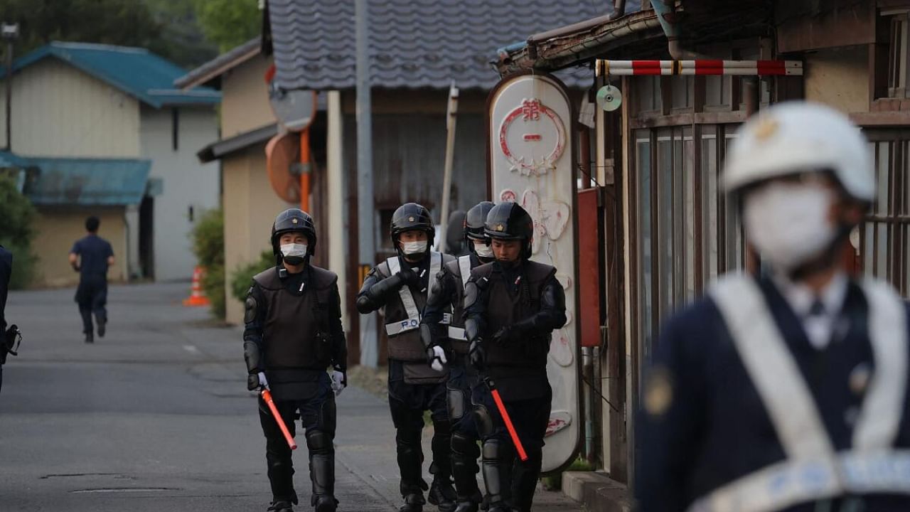 Police officers are seen near the scene of a standoff where a suspect, believed to be a farmer in his 30s, was holed up inside a building in the Ebe area of Nakano, Nagano Prefecture, early morning on May 26, 2023. Credit: AFP Photo