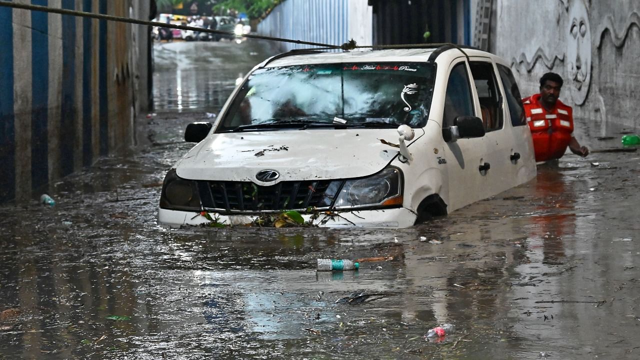Fire and Emergency personnel enter the inundated underpass near KR Circle to flush out a car where a woman lost her life following heavy rains in Bengaluru. Credit: DH Photo/Puskar V