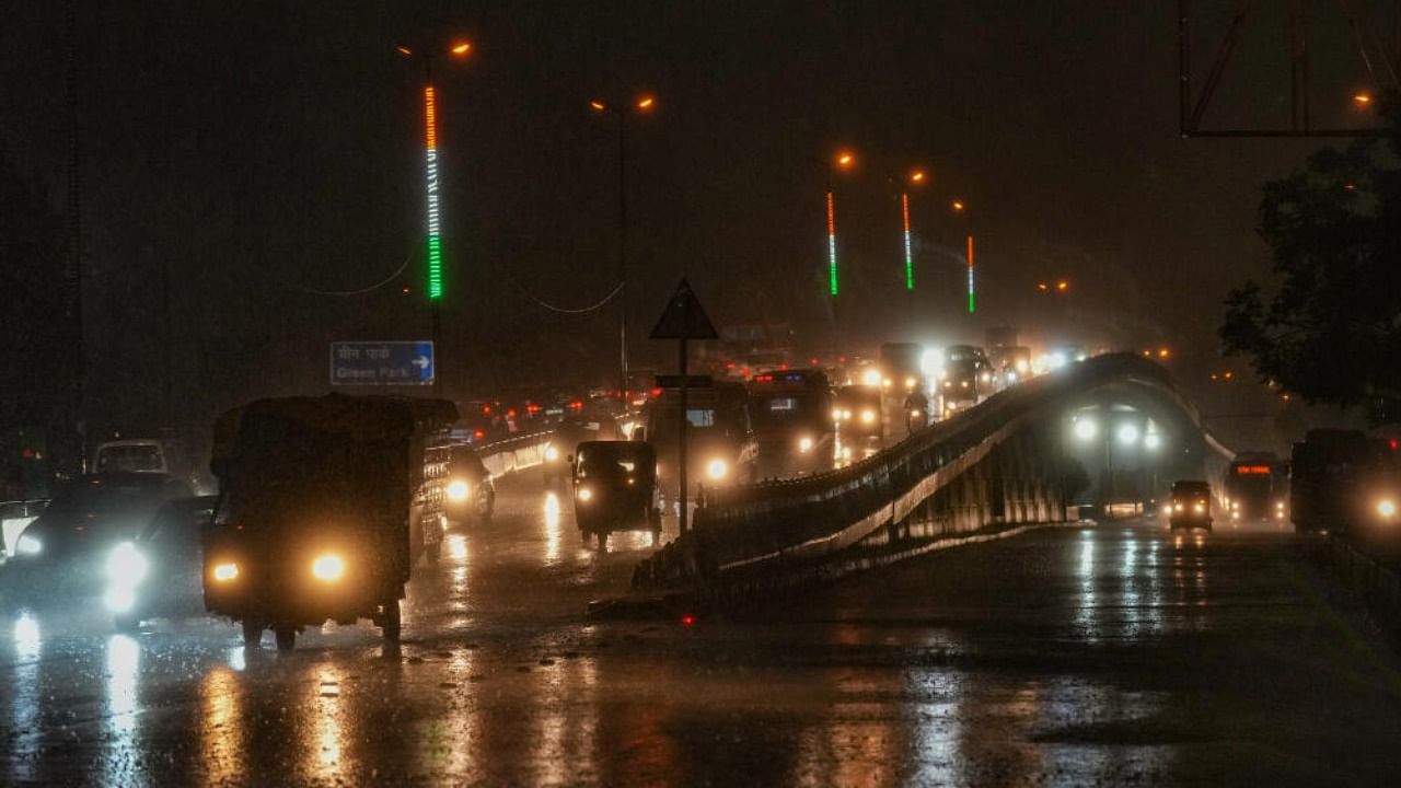 Vehicles ply on a road during rains, in New Delhi. Credit: PTI Photo