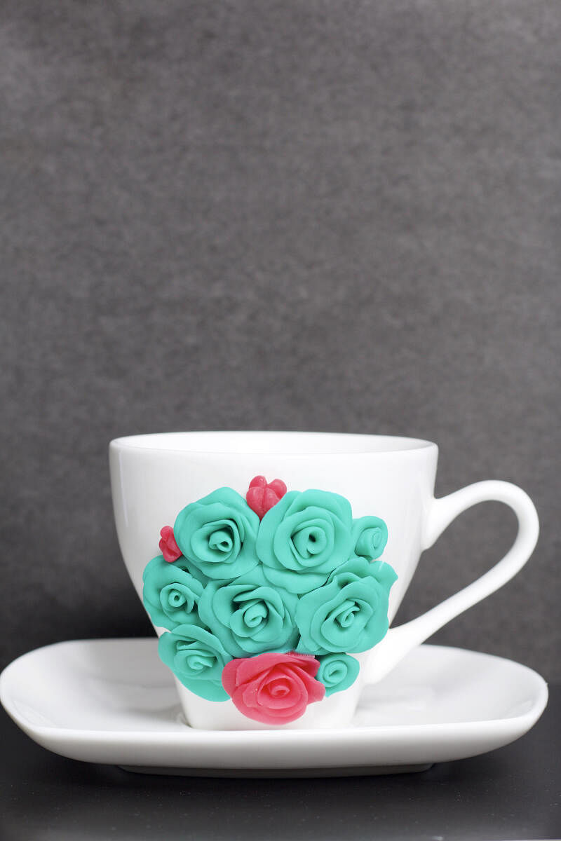 Work with polymer clay on a plain white cup to make decor.