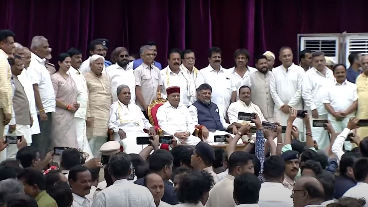 Karnataka Chief Minister Siddaramaiah, Governor Thawar Chand Gehlot, and Dy CM D K Shivakumar pose for a photo with newly inducted ministers. Credit: YouTube/Chief Minister