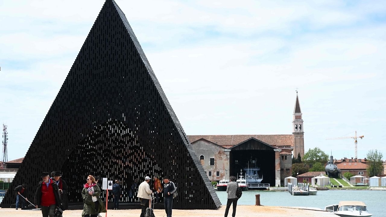Visitors look at the installation "KwaeE" by Adjaye Associated at the 18th International Architecture Exhibition in Venice on May 18, 2023, during a press day. Credit: AFP Photo