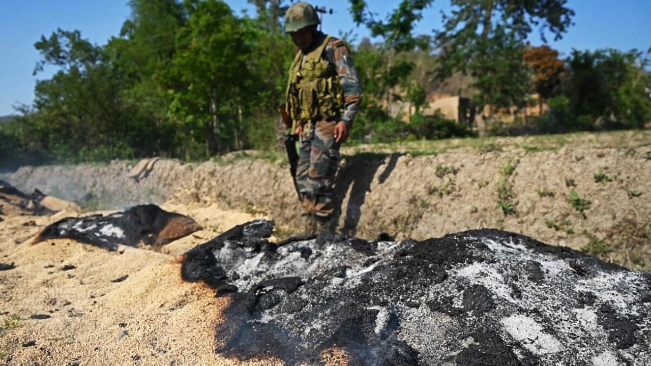 Indian army soldier examines site of violence in Manipur. Credit: AFP Photo