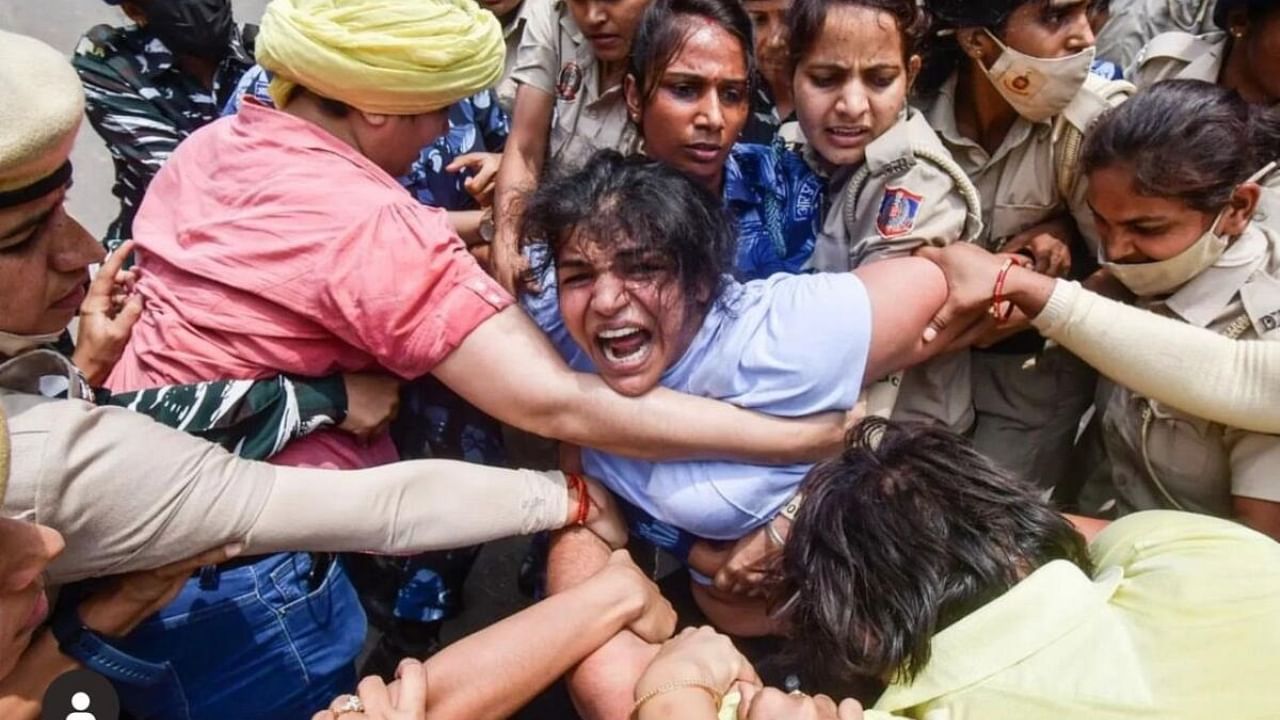 Wrestler Sakshi Malik being detained by police during wrestlers' protest march towards new Parliament building. Credit: IANS Photo