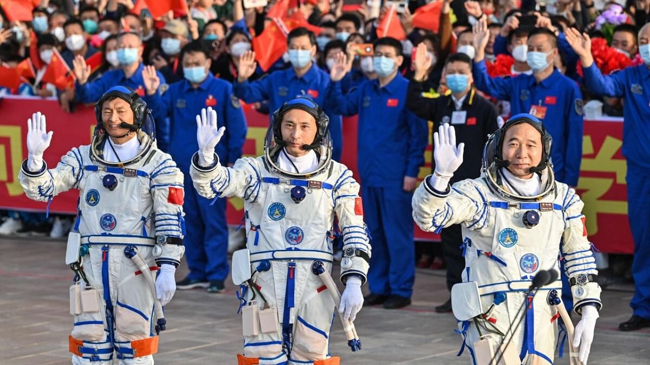 Gui Haichao (L) payload expert, Zhu Yangzhu (C) space flight engineer and commander Jing Haipeng (R) wave during the seeing-off ceremony before boarding a Long March-2F carrier rocket carrying the Shenzhou-16 Manned Space Flight Mission at the Jiuquan Satellite Launch Centre in China's northwestern Gansu province. Credit: AFP Photo