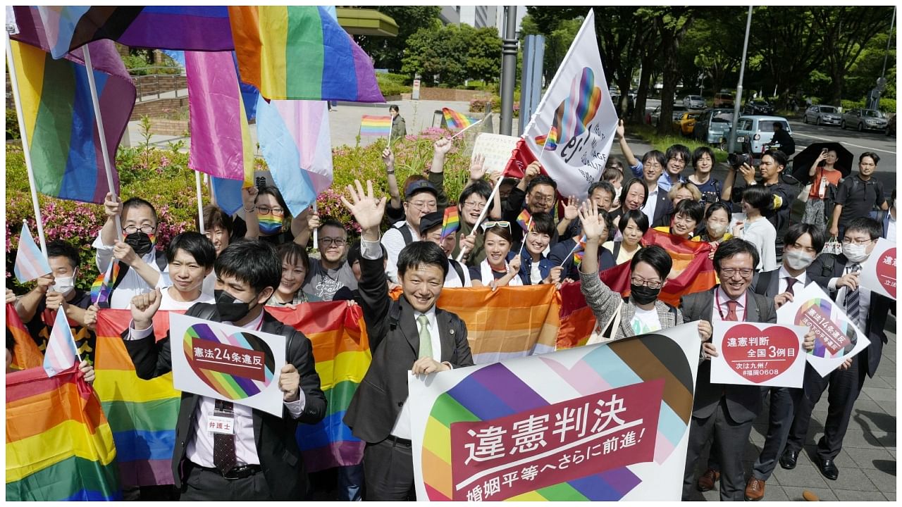 People including plaintiffs' lawyers hold banners and flags, after the lower court ruled that not allowing same-sex marriage was unconstitutional, outside Nagoya district court. Credit: Reuters Photo