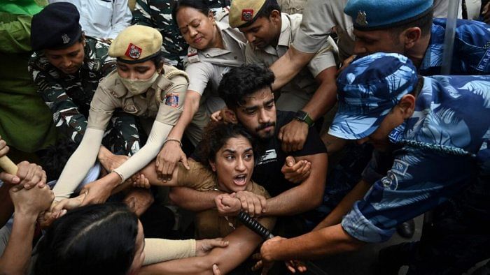 Indian wrestlers Vinesh Phogat (C) with others are detained by the police while attempting to march to India's new Parliament. Credit: AFP Photo