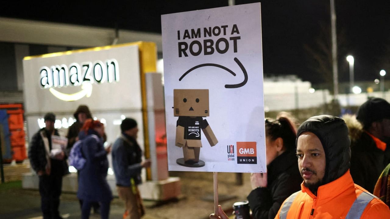 A man holds a sign during a rally in support of Amazon workers' on strike, outside the Amazon warehouse, in Coventry, Britain, January 25, 2023. Credit: Reuters Photo