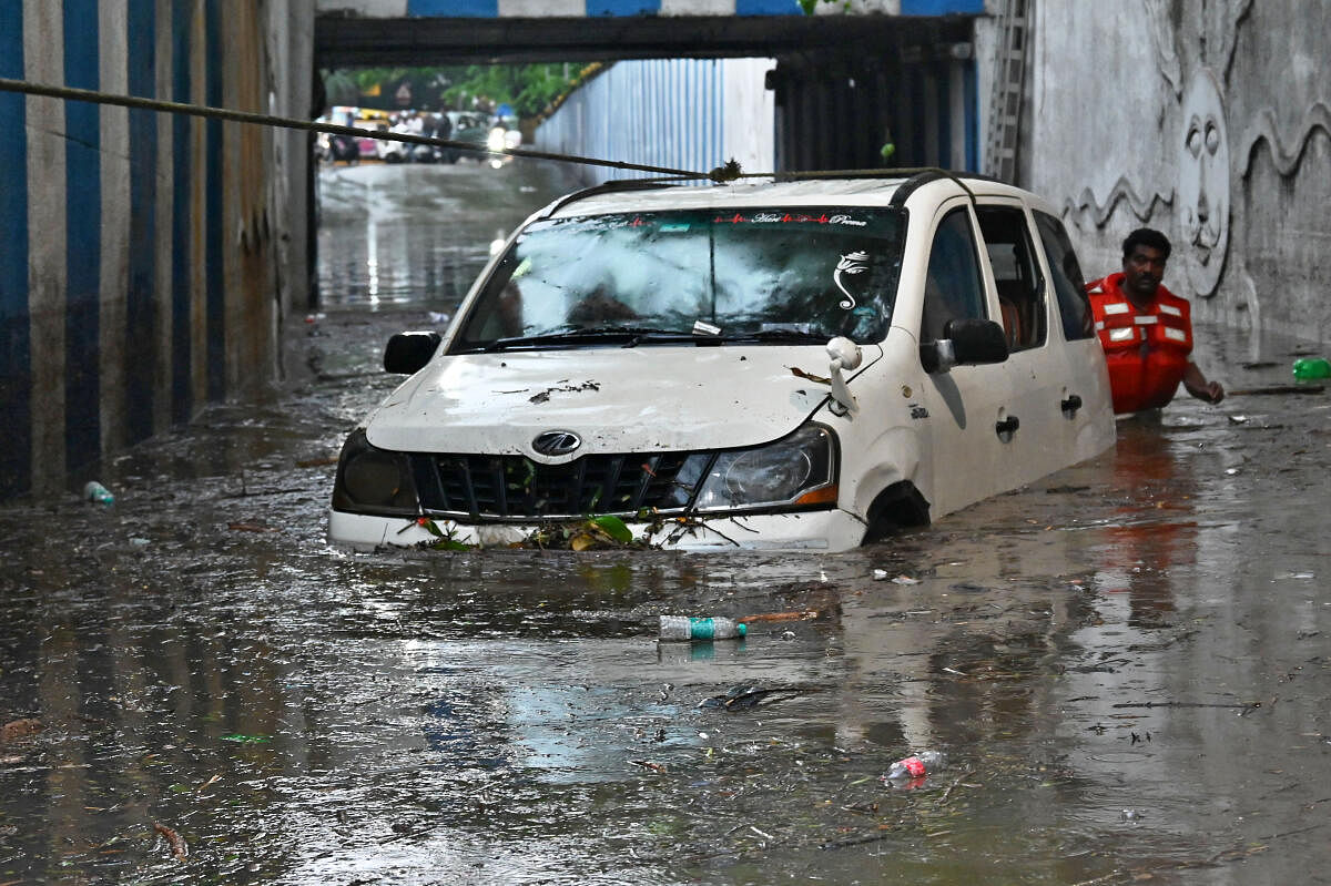 Fire and Emergency personnel flushes out the car near KR Circle. DH PHOTO by PUSHKAR V