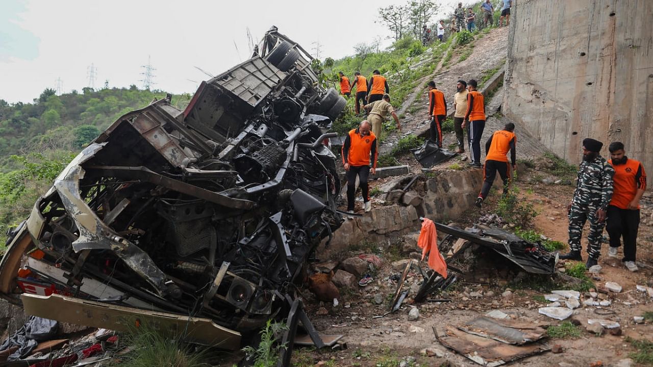 Rescue teams check the wreckage of the bus after the accident. Credit: PTI Photo