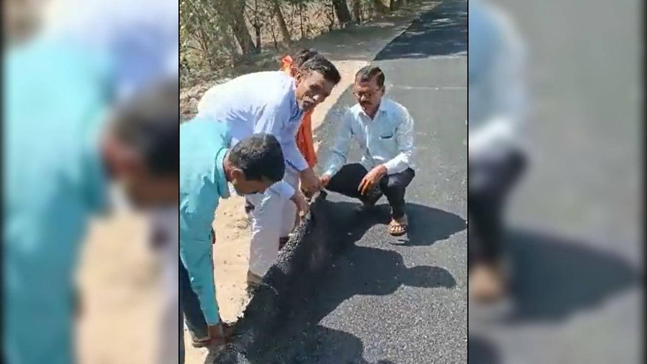 Villagers lifting up the road to highlight its poor quality. Credit: Twitter/@AhmedKhabeer_