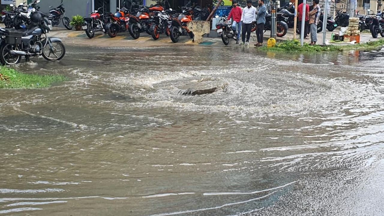 Residents of OMBR Layout, Kasturi Nagar, had to deal with an overflowing manhole on Tuesday. Credit: DH PHOTO